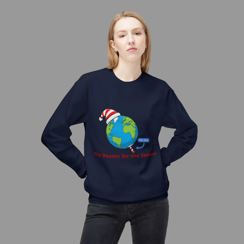 Person wearing a navy blue sweatshirt with a graphic of tilted Earth wearing a Santa hat and text 'The Reason for the Seasons' on a white background. 