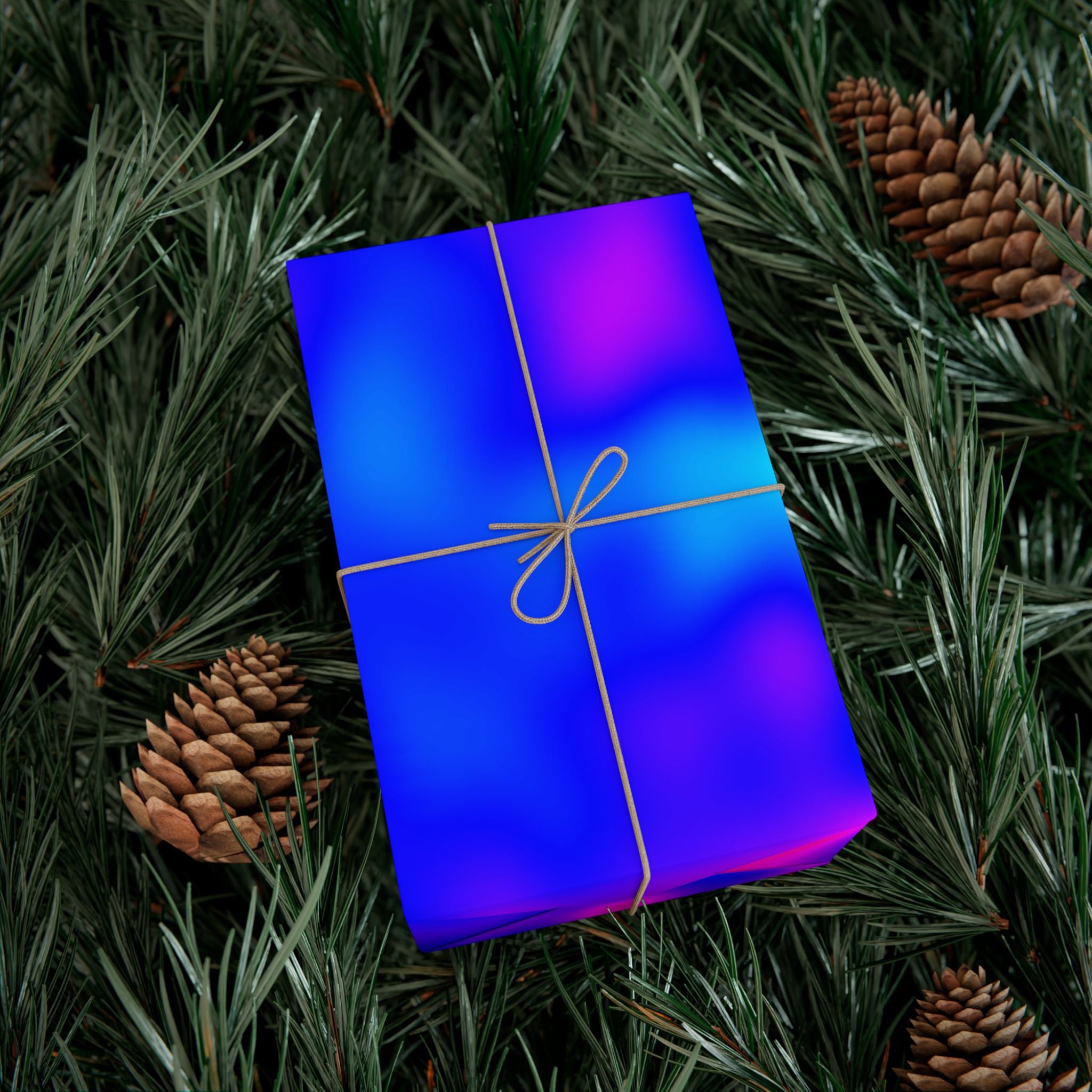 Blue and purple pattern of cosmic microwave background wrapeed gift box with a bow on a bed of pine needles and pine cones